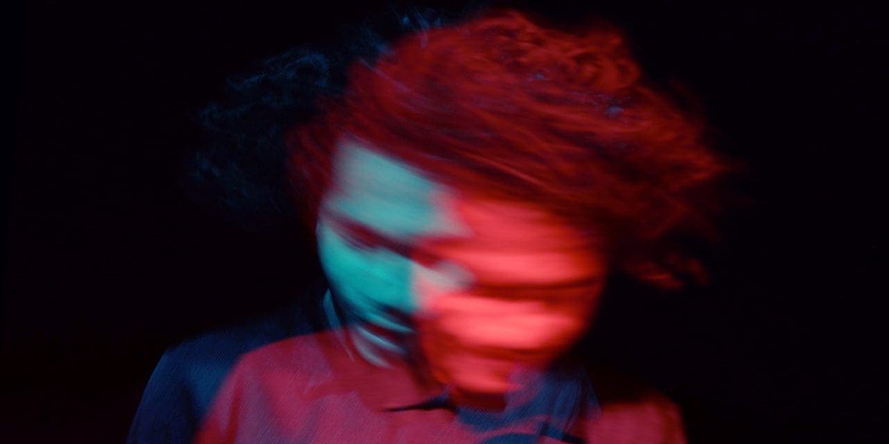 blurry image of man shaking his head