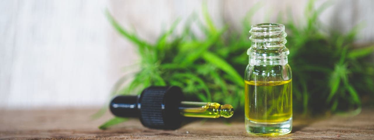 A bottle of cannabis tincture with the dropper cap on its side